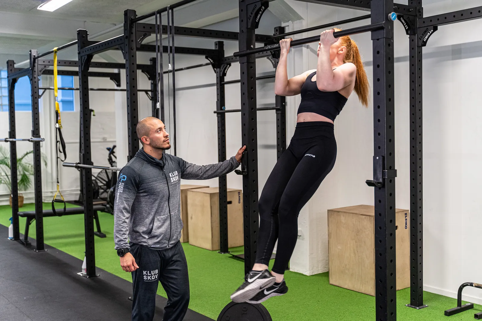 Coach rasmus og sin klient som træner pullups